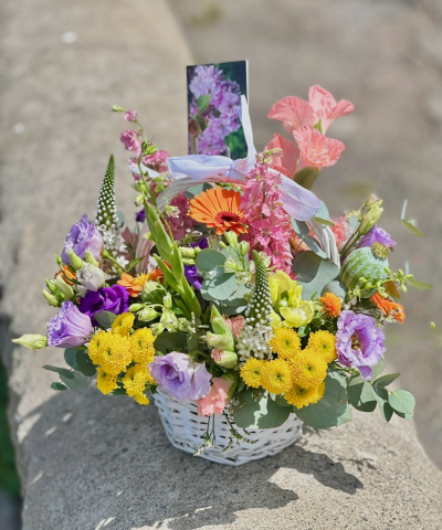 Summer Garden Basket - A cheerful and elegant basket arrangement bursting with soft pastel tones, vibrant seasonal textures, and natural greenery. Designed with a charming countryside feel, this handcrafted display features a delicate ribbon detail and a thoughtful photo insert, making it perfect for heartfelt gifting, celebrations, remembrance, or brightening someone’s day with a touch of beauty and warmth.