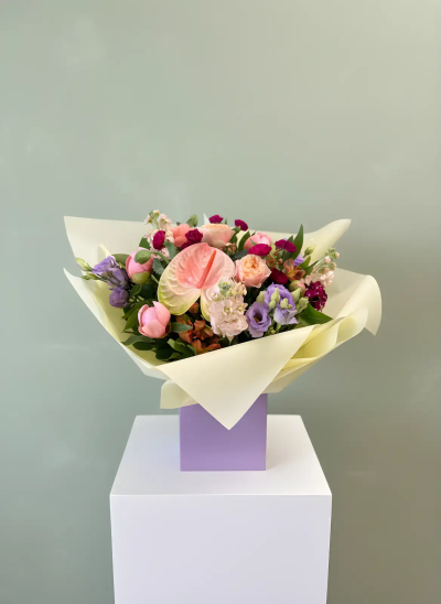 Blush Elegance Hand-Tied Bouquet - A beautifully presented hand-tied bouquet featuring a harmonious blend of soft pastel shades, rich berry tones, and fresh greenery. Expertly arranged and wrapped in elegant presentation paper, this design combines delicate textures with contemporary style to create a truly sophisticated gift. Perfect for birthdays, anniversaries, thank-you gestures, celebrations, or simply brightening someone's day, this bouquet brings warmth, beauty, and a touch of luxury to any occasion. Its graceful colour palette and modern presentation make it a thoughtful and memorable floral gift.