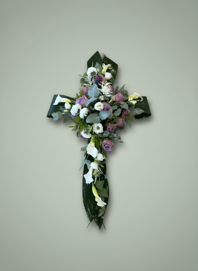 Woodland cross - A beautiful handmade floral cross arranged on a natural willow base, featuring elegant calla lilies, delicate blooms, and lush seasonal foliage. Thoughtfully designed to create a graceful and meaningful tribute, each cross is handcrafted to order. Flower colours can be customised to suit your preference, creating a truly personal farewell. Flowers may vary slightly depending on seasonal availability.